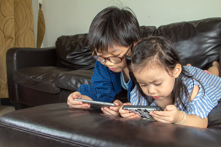 Happy boy and girl playing game online.の写真素材