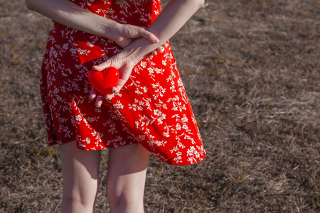 back view of woman holding red heart, copy space in the concept of love and romanticの写真素材
