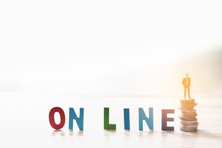 Business man standing on stack coins with wooden textの写真素材