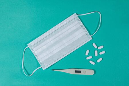 White Surgical face mask ,thermometer and medical . pollution, virus, flu and coronavirus concept.