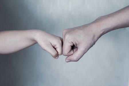 Fist bump - father and son.Adult man and child giving fist bump, trustful and friendly relations, supportの写真素材