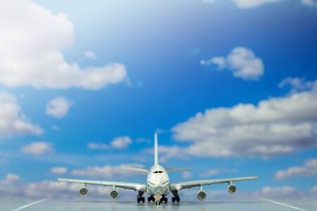 model air plan on runway with blue sky background.