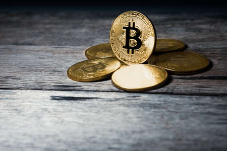 Golden Bitcoin on wooden table.の写真素材