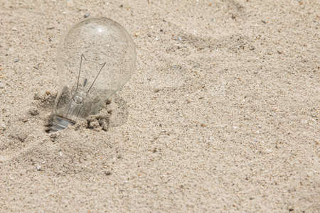 Light bulb on the beach for clean energy and knowledge concept.の写真素材