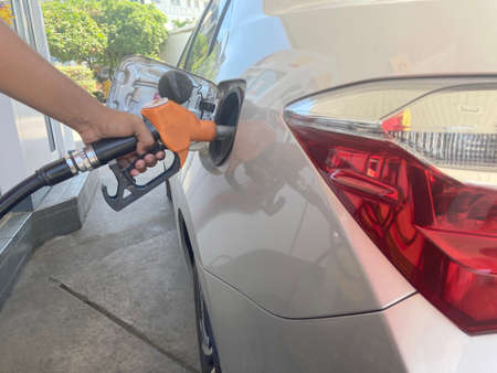Hand refilling the car with fuel at the refuel station