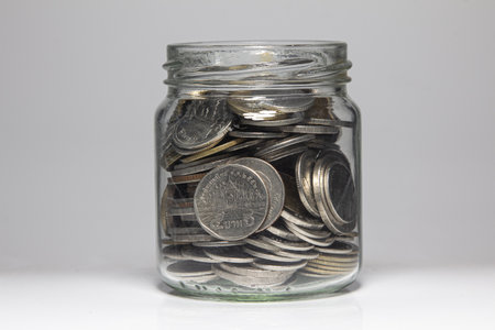 Many coin in the bottle on a white background,Bank and Money concept.の写真素材