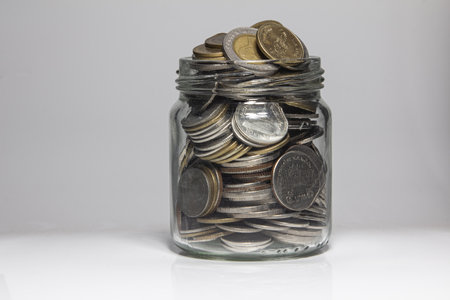 Many coin in the bottle on a white background,Bank and Money concept.の写真素材