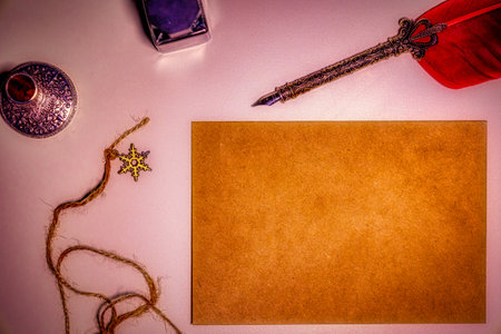 Quill pen and ink well laying on blank parchment paper with copy space for messageの写真素材