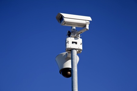 daylight shot of two security cameras on blue sky background 