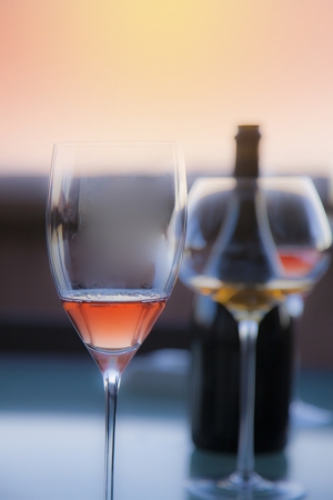 photo of glasses and bottle on a sunset balconyの写真素材