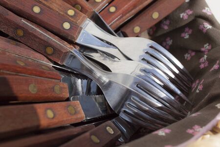 cutlery on the heap in basket covered with tablecloth