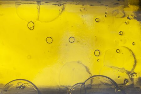 studio shot of a pumpkin oil bottle detail of frozen bubbles as surrealistic background