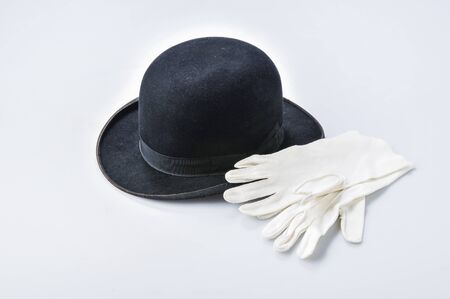 an antique black melon hat and a pair of white gloves on a slightly darker backgroundの写真素材