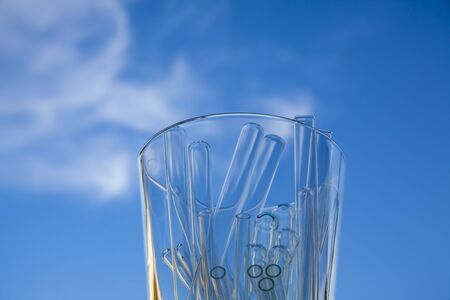 glass container full of empty glass tubes photographed on the sky background