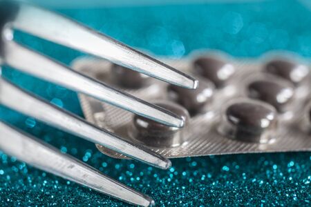 Selective Focus Macro Photo of Fork Infront the Blister of B12 Vitamin Pillsの写真素材