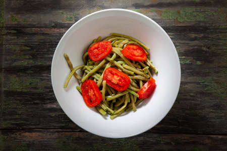 Cooked Green Beans in White Bowl With Tomatoes on Wooden Background