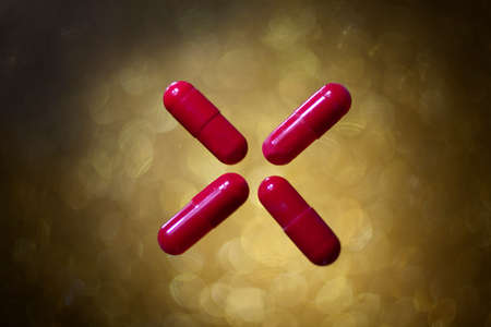 Oval Red Pills Cross As Aid for All Diseases on Gold Bokeh Background