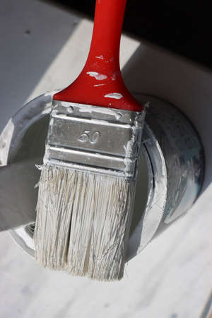 Workshop Photo of Used Paintbrush Lying on Top of Can. White Color Dirt Over Can.の写真素材
