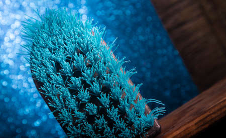 Plastic Blue Brush on Wooden Shelf Inclinated.Selective Focus is in the middle of the of Plastic...