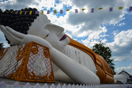 Reclining Buddha statue with beautiful sky and white clouds background.の写真素材