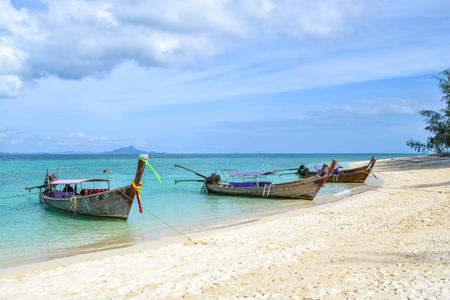 Four Long tail boat in blue sea in holiday and white beach with beautiful sky background Andaman sea krabi Thailandの写真素材