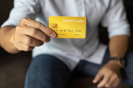 businessman show credit card, man sitting on sofa Living room at home.の写真素材