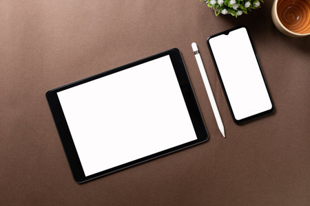 Black tablet with white blank screen is on top of brown paper with supplies. Top view, flat lay.の写真素材