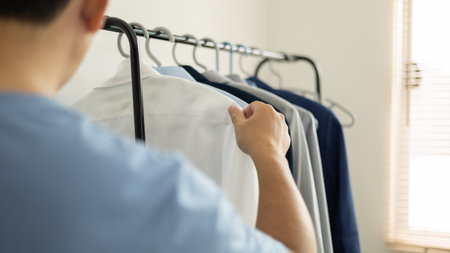 man is choosing shirt in the clothes room at home.の写真素材