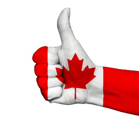 Hand with thumb up painted in colors of Canada flag isolated on white backgroundの写真素材