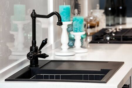 Modern black kitchen sink and faucet in room interiorの写真素材