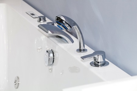 Modern faucet of chrome color in bathroom interior