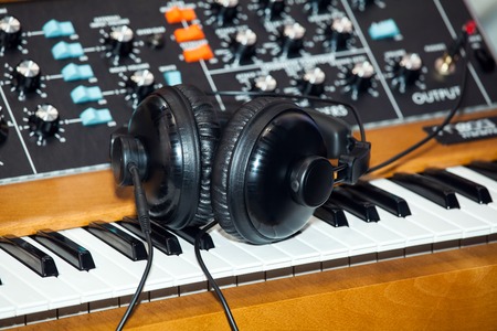 Black headphones on the keyboard piano, musical backgroundの写真素材