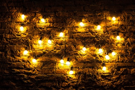 Brick wall with light bulbs glowing backgroundの写真素材