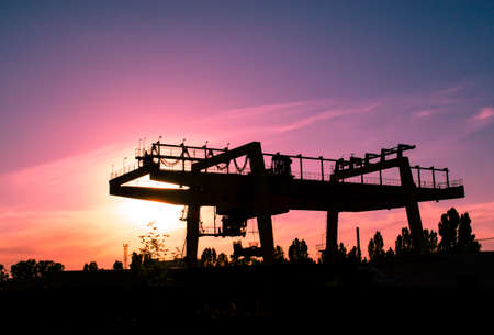 Industrial iron large metal gantry crane mounted on the supports for lifting and carrying heavy...