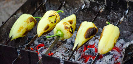 Sweet pepper on a skewer preparing to be grilled on charcoal closeup blurred background. bell pepperの写真素材