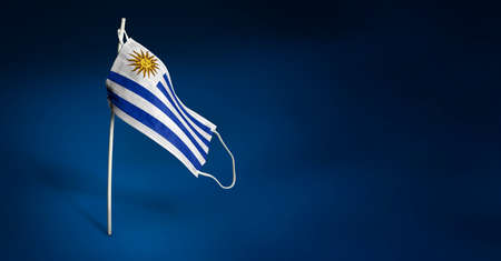 Waving flag of the Uruguay painted on medical mask on pole.の写真素材