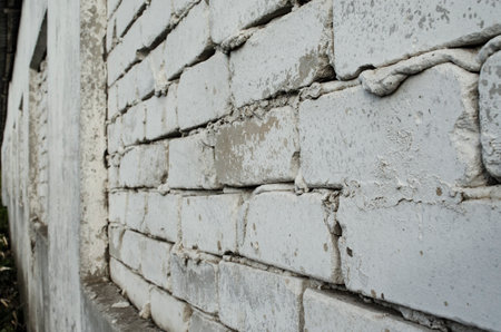 White painted old brick wall, perspective view from right-hand side.. Angle view, abstract background photoの写真素材