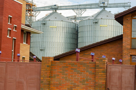 Granary among the houses. Neighborhood of a grain storage with a townhouse. industry and household....
