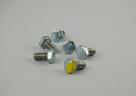 Hex head bolt screws thread on white background. High quality phot. one bold is stand out of all.