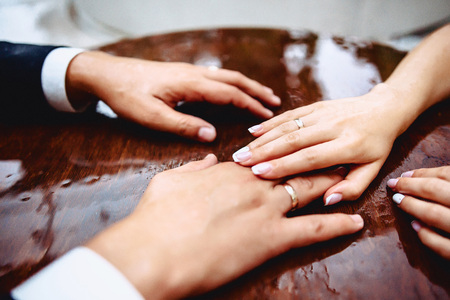 Brides hands on the table with drops of water during rain with reflectionの写真素材