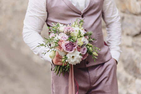 the groom holds elegant wedding bouquet in his handsの写真素材