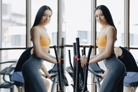 young attractive girl at gym on exercise bike, fitness and yoga trainingの写真素材