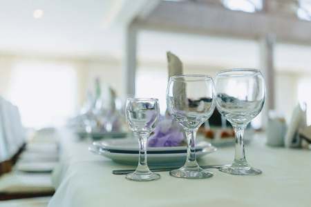 dishes on banquet tables, serving glasses, spoons and plates in restaurantの写真素材