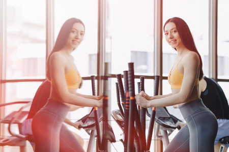 young attractive girl at gym on exercise bike, fitness and yoga trainingの写真素材