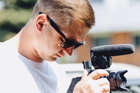 cameraman with a camera on a mono-pod at shooting