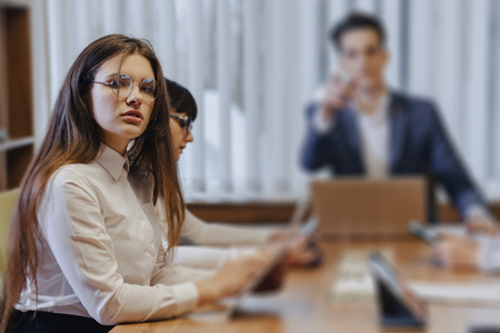 Stylish young different people in the modern office work at one desk with documents and a laptopの写真素材