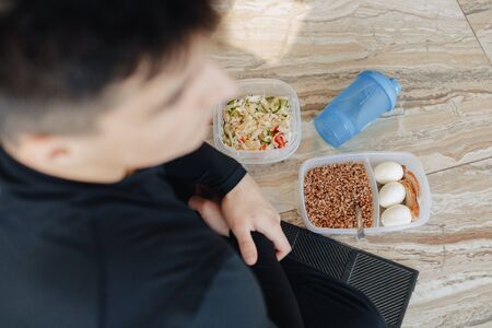 stylish guy in the gym relaxing on the floor and eating healthy food. Healthy Lifestyle.の写真素材