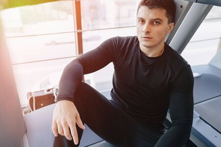 stylish guy in the gym sits resting on the treadmill. Healthy Lifestyle. wellness.の写真素材
