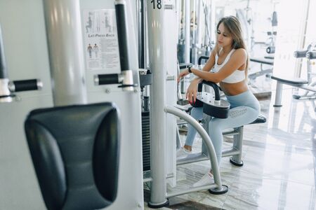 attractive sports girl resting on the simulator and smiling nicely. healthcare and wellness.の写真素材