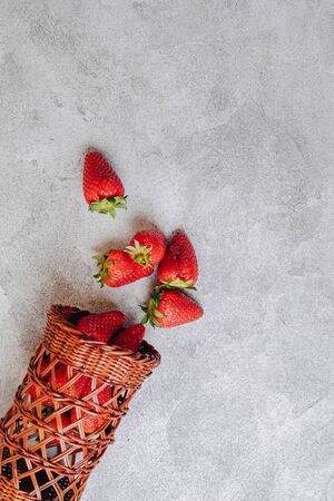 juicy strawberries poured out chaotically on a concrete light background. delicious fruits in summer season. natural products and natural resources. simple picture.の写真素材